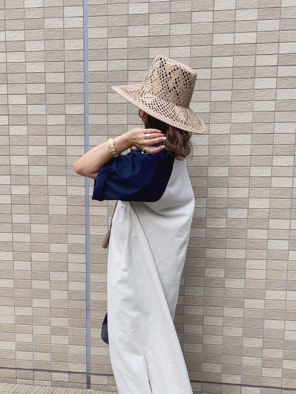 オレンジ系のシャツ/ブラウス、ベージュ系のハットを着用したレディースの夏コーディネートの3枚目の写真