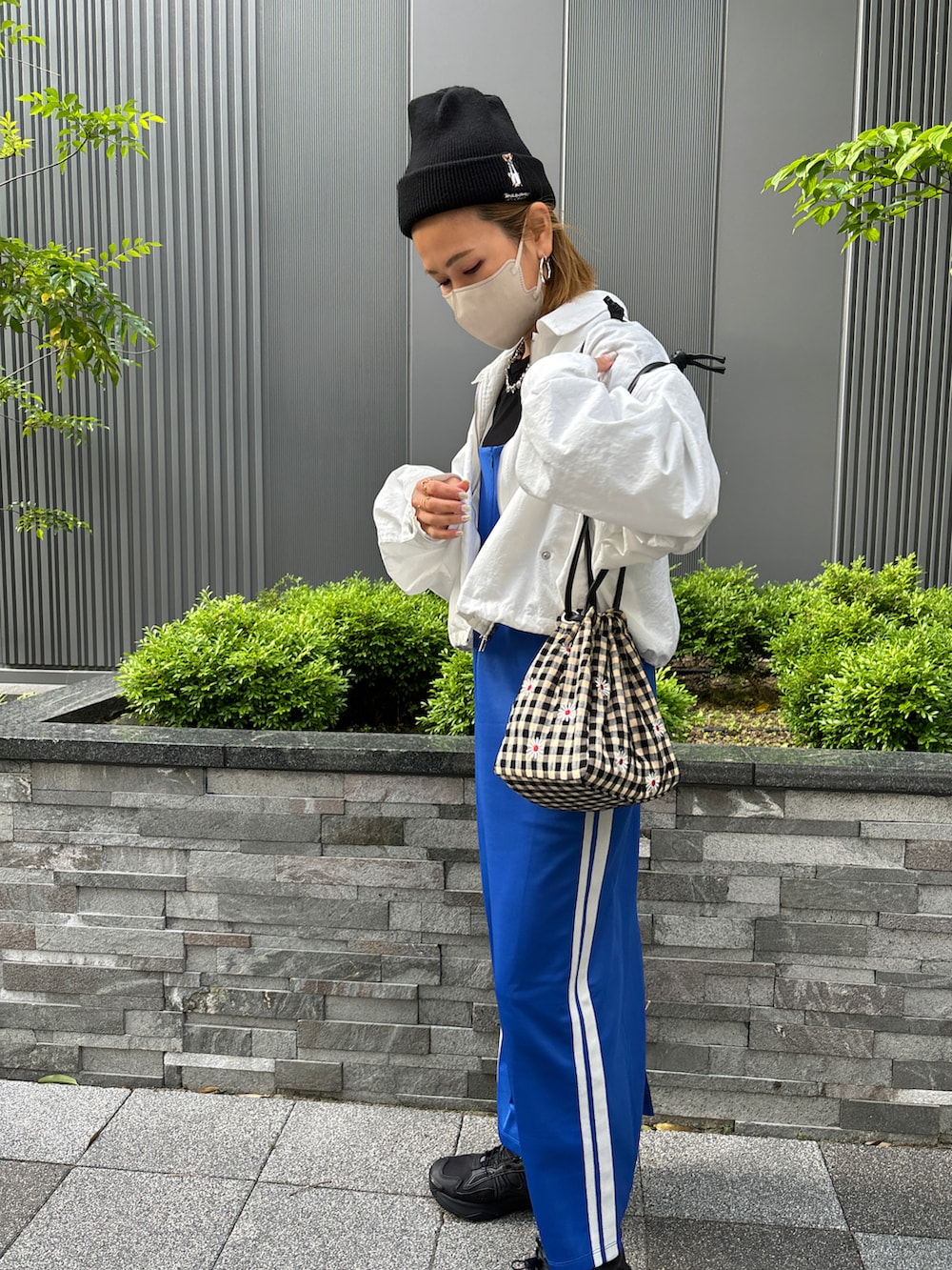 ブルー系のワンピース、ホワイト系のナイロンジャケットを着用したレディースの春コーディネートの3枚目の写真
