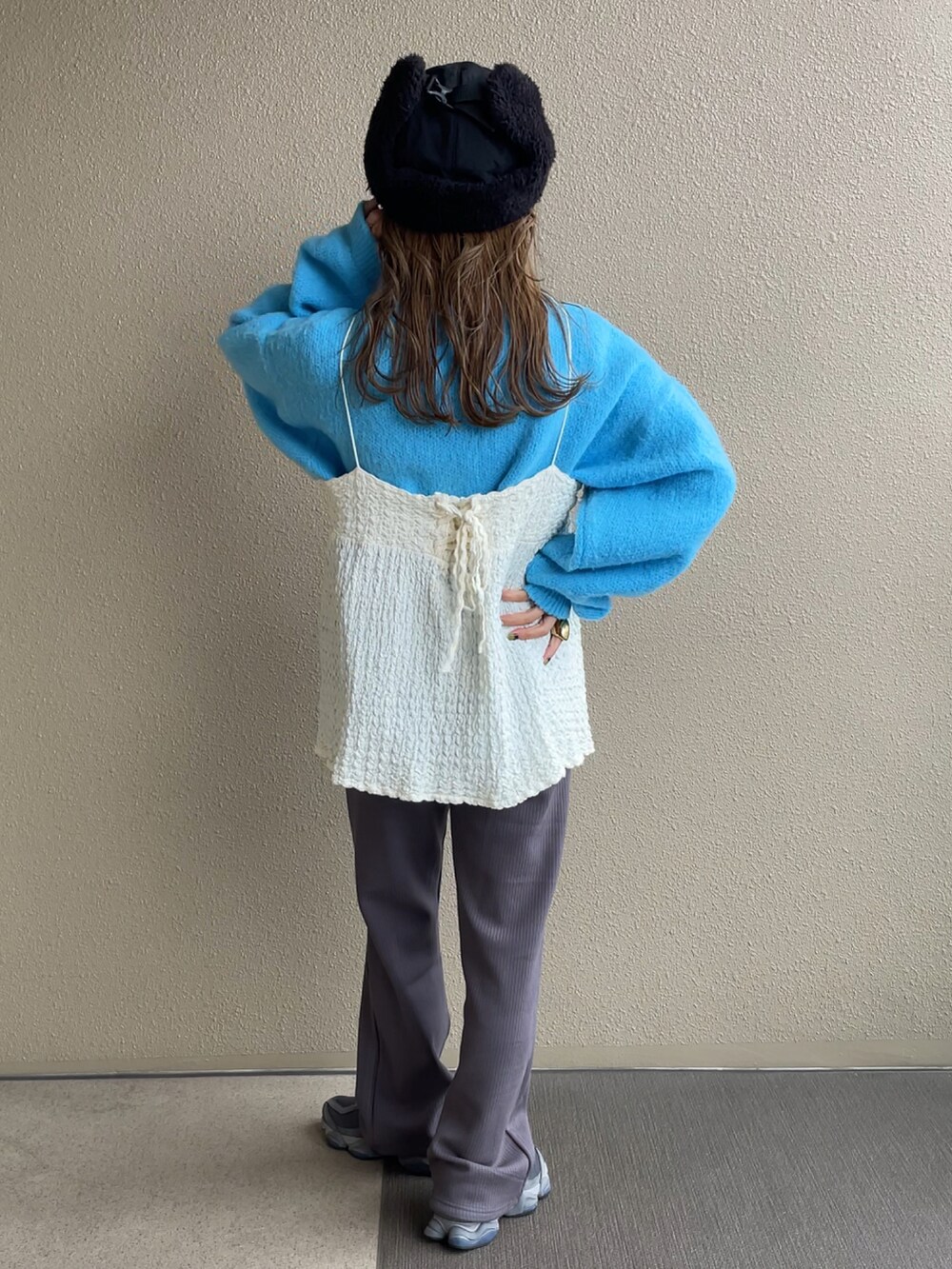 ブルー系のニット/セーター、ホワイト系のシャツ/ブラウス、グレー系のその他パンツを着用したレディースの秋コーディネートの2枚目の写真