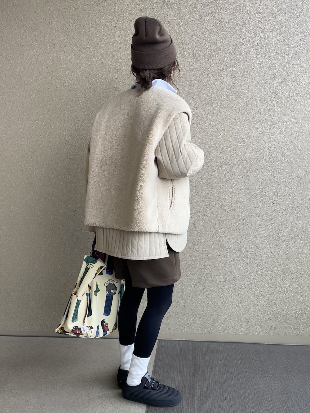 ベージュ系のスウェット、ブラウン系のパンツ、ホワイト系のトートバッグを着用したレディースの冬コーディネートの2枚目の写真