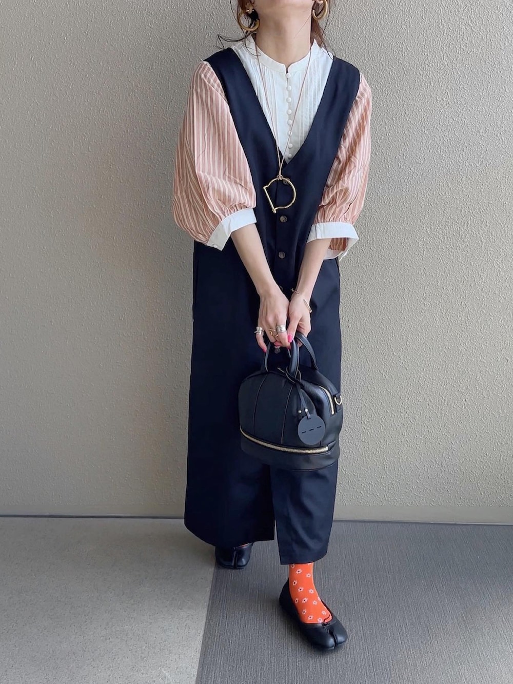 ブルー系のデニムスカート、ブラック系のジャンパースカート、その他のその他を着用したレディースの春コーディネートの3枚目の写真