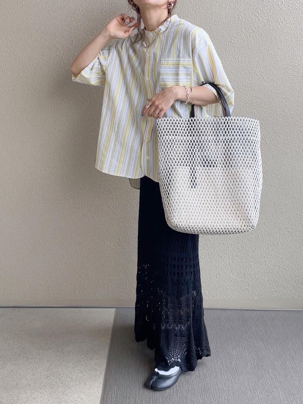 イエロー系のシャツ/ブラウス、ブラウン系のワンピース、ブラウン系のサンダルを着用したレディースの春コーディネートの2枚目の写真