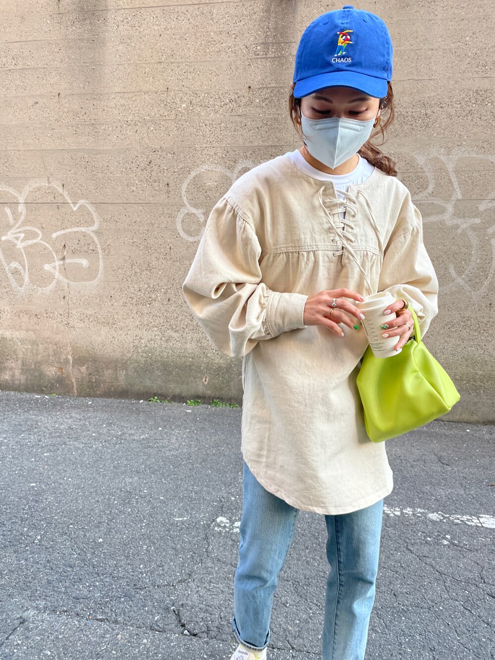 ホワイト系のスニーカー、ブルー系のデニムパンツ、ホワイト系のシャツ/ブラウスを着用したレディースの冬コーディネートの5枚目の写真