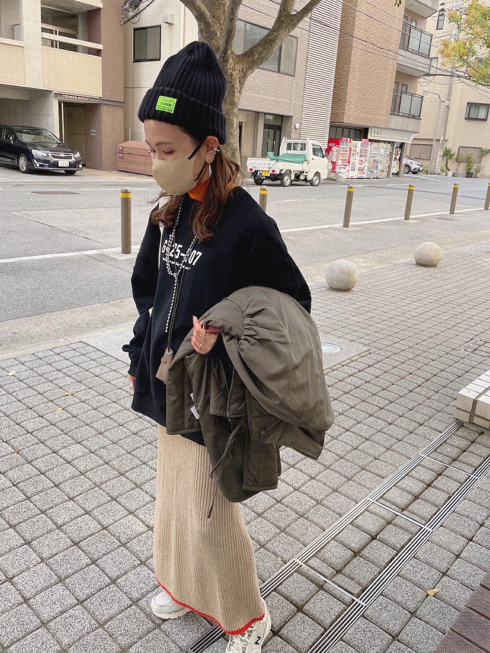 グリーン系のダウンジャケット/コート、ブラック系のスウェット、ホワイト系のスニーカーを着用したレディースの秋コーディネートの4枚目の写真