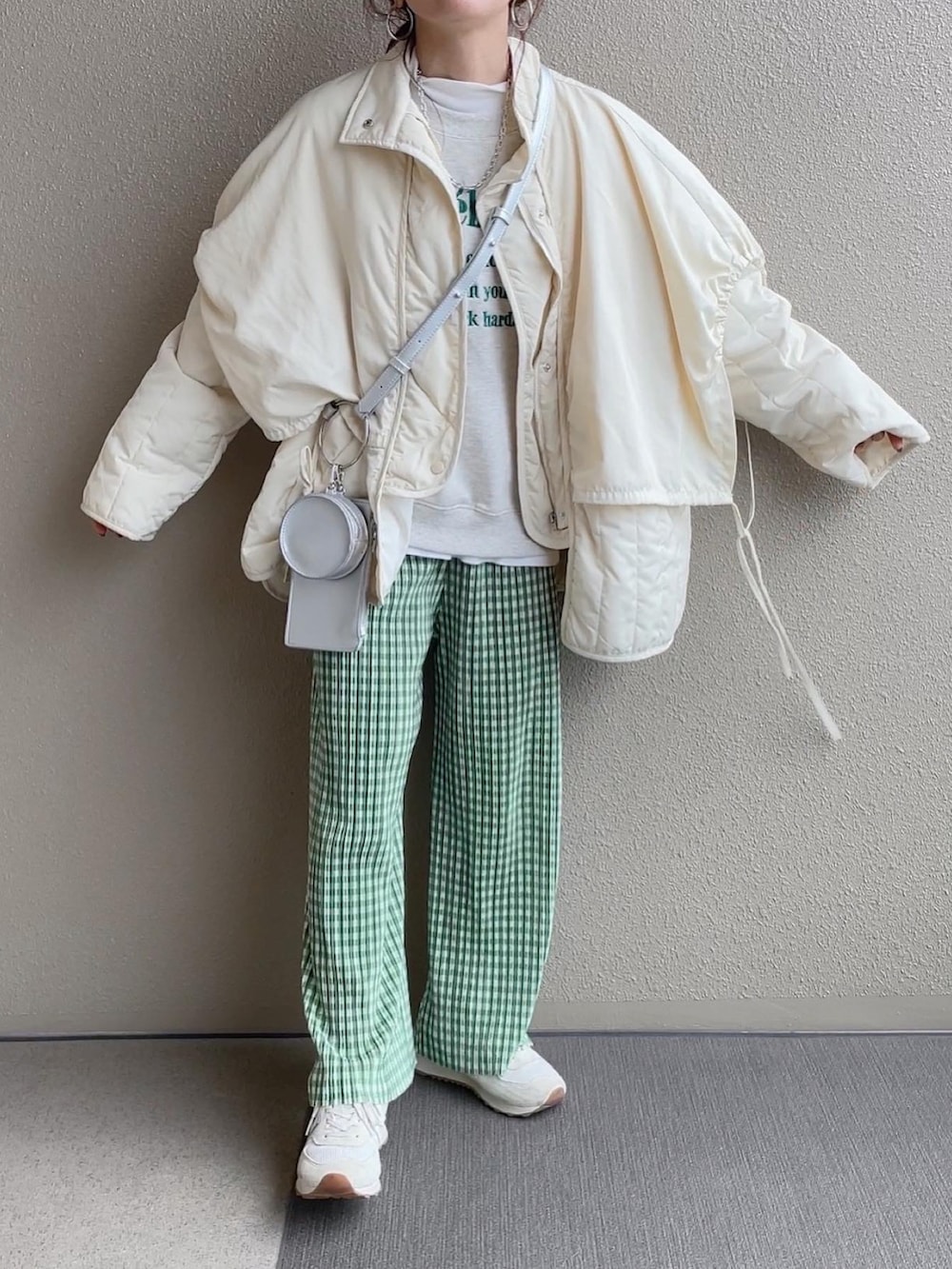 ホワイト系のダウンジャケット/コート、グレー系のスウェット、ホワイト系のショルダーバッグを着用したレディースの冬コーディネートの2枚目の写真