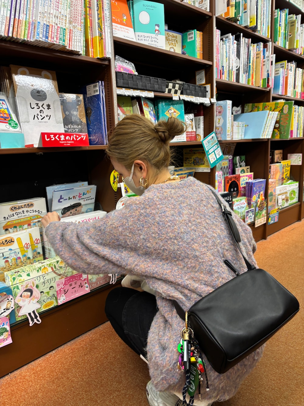 ブラック系のショルダーバッグ、ピンク系のニット/セーターを着用したレディースの冬コーディネートの2枚目の写真