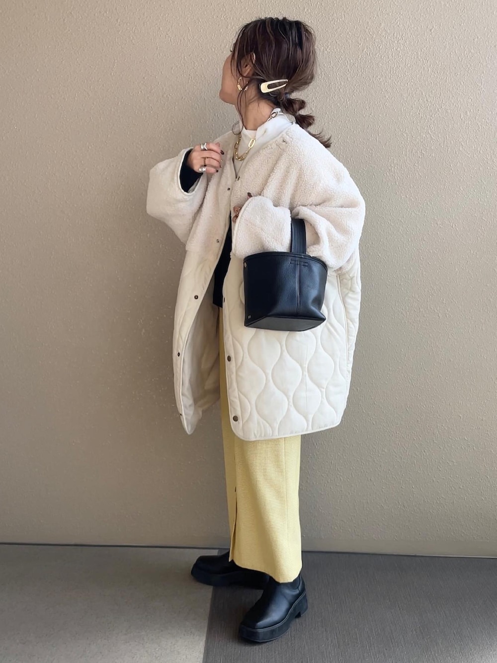 ブラック系のカーディガン/ボレロ、イエロー系のスカート、ホワイト系のノーカラージャケットを着用したレディースの冬コーディネートの3枚目の写真