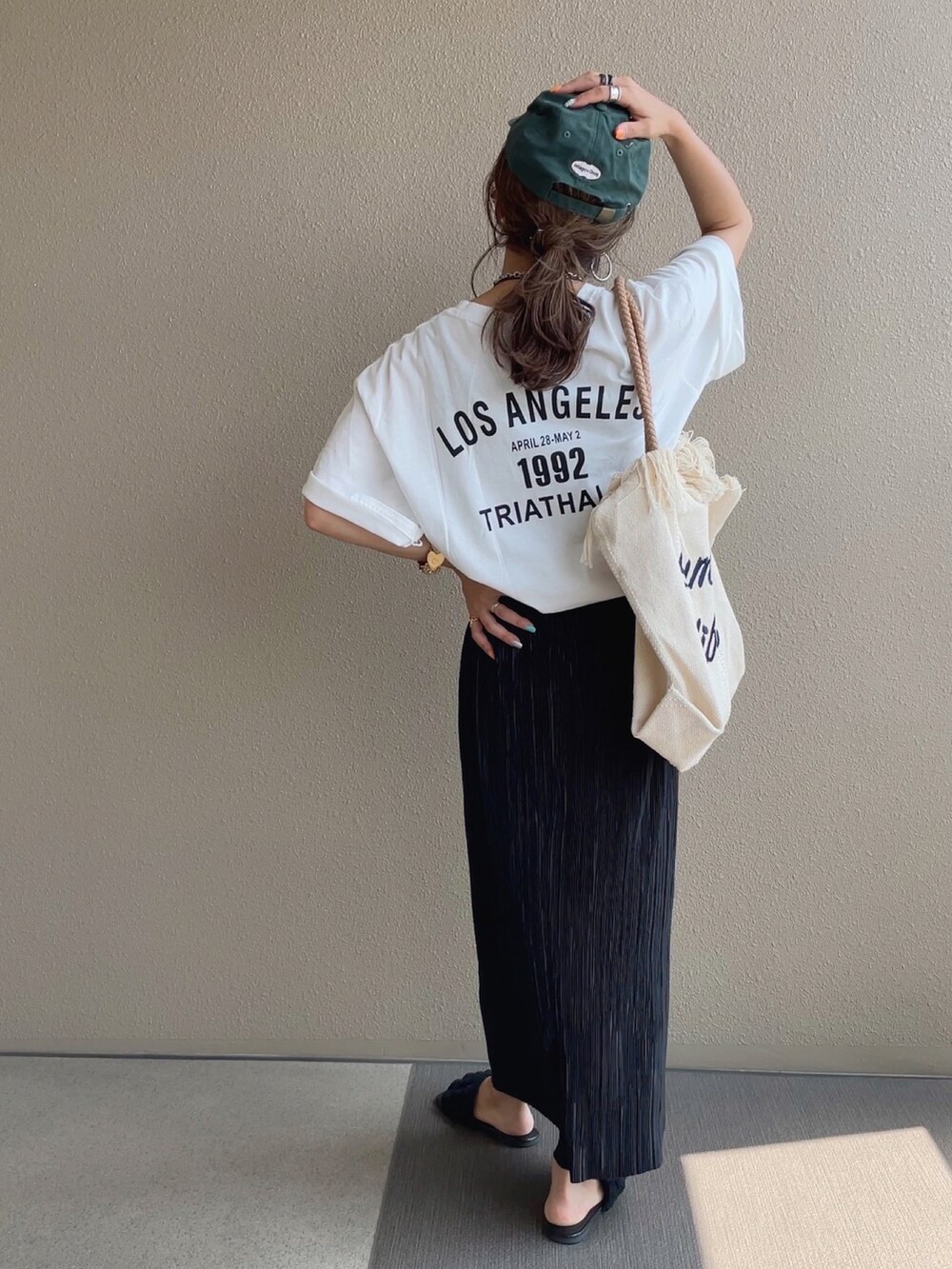 ホワイト系のTシャツ/カットソー、ホワイト系のトートバッグ、ブルー系のデニムパンツを着用したレディースの夏コーディネートの4枚目の写真