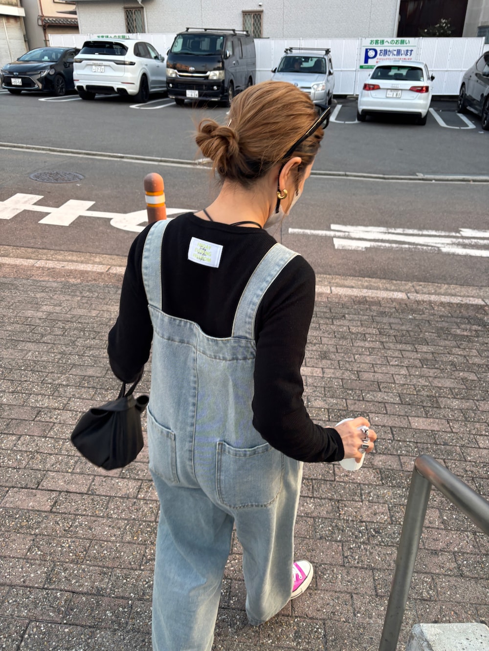ブルー系のサロペット/オーバーオール、ピンク系のスニーカー、ブラック系のTシャツ/カットソーを着用したレディースの冬コーディネートの2枚目の写真