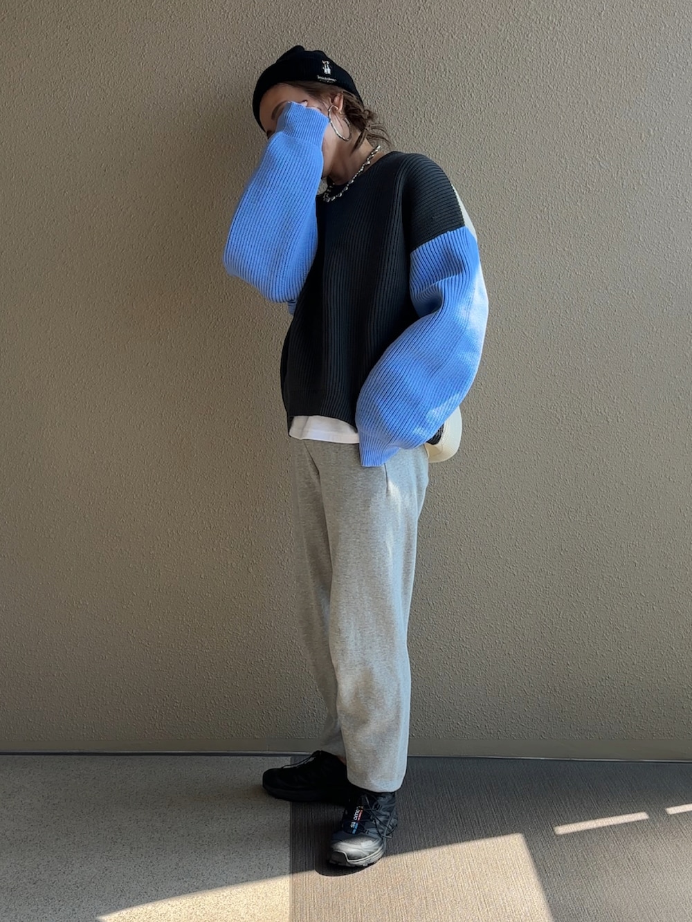 グレー系のニット/セーター、グレー系のスウェットパンツ、ブラック系のニットキャップ/ビーニーを着用したレディースの秋コーディネートの3枚目の写真