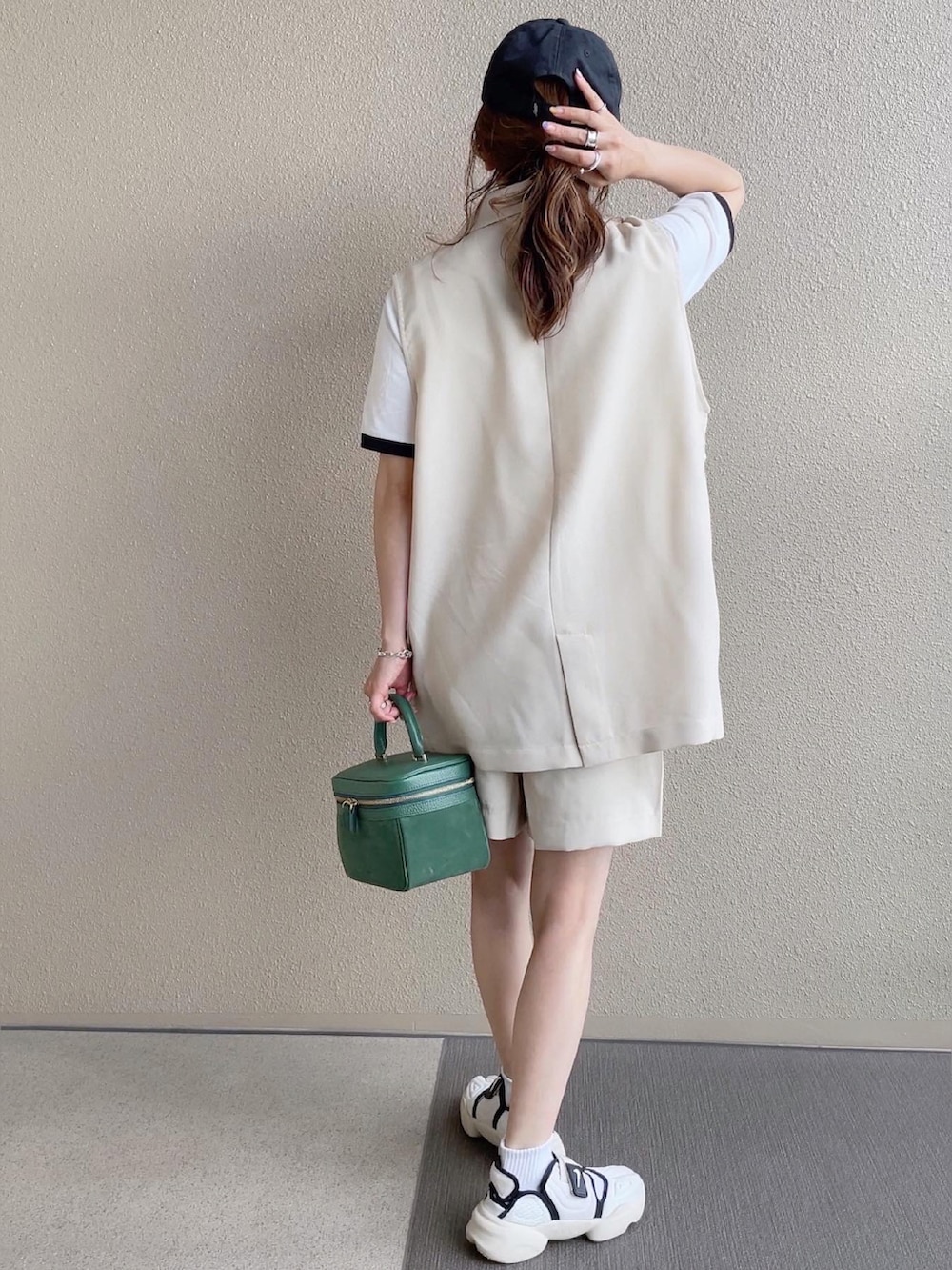 ホワイト系のスラックス、ブラック系のTシャツ/カットソー、ホワイト系のベストを着用したレディースの春コーディネートの2枚目の写真