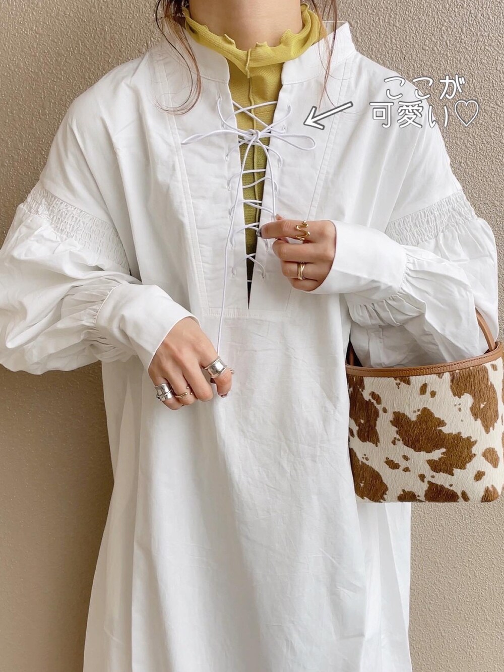 ホワイト系のワンピース、グリーン系のTシャツ/カットソー、ベージュ系のハンドバッグを着用したレディースの冬コーディネートの3枚目の写真