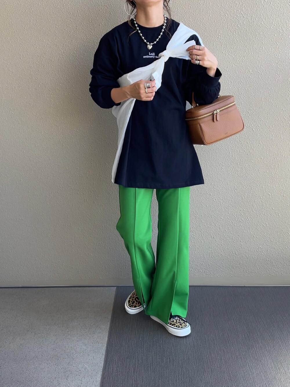 ベージュ系のスウェット、グリーン系のベスト、グリーン系のスラックスを着用したレディースの秋コーディネートの2枚目の写真