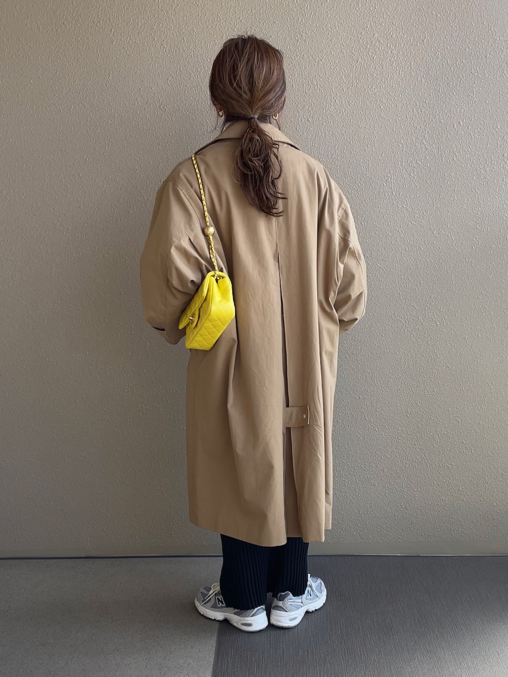 グリーン系のカーディガン/ボレロ、ブラック系のスカート、ベージュ系のステンカラーコートを着用したレディースの冬コーディネートの5枚目の写真