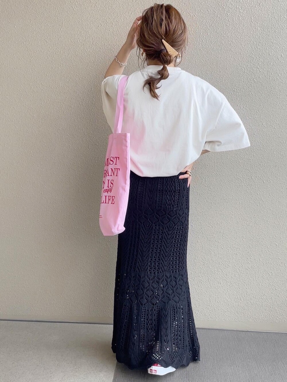 ベージュ系のTシャツ/カットソー、ブラック系のスカート、ピンク系のトートバッグを着用したレディースの春コーディネートの3枚目の写真