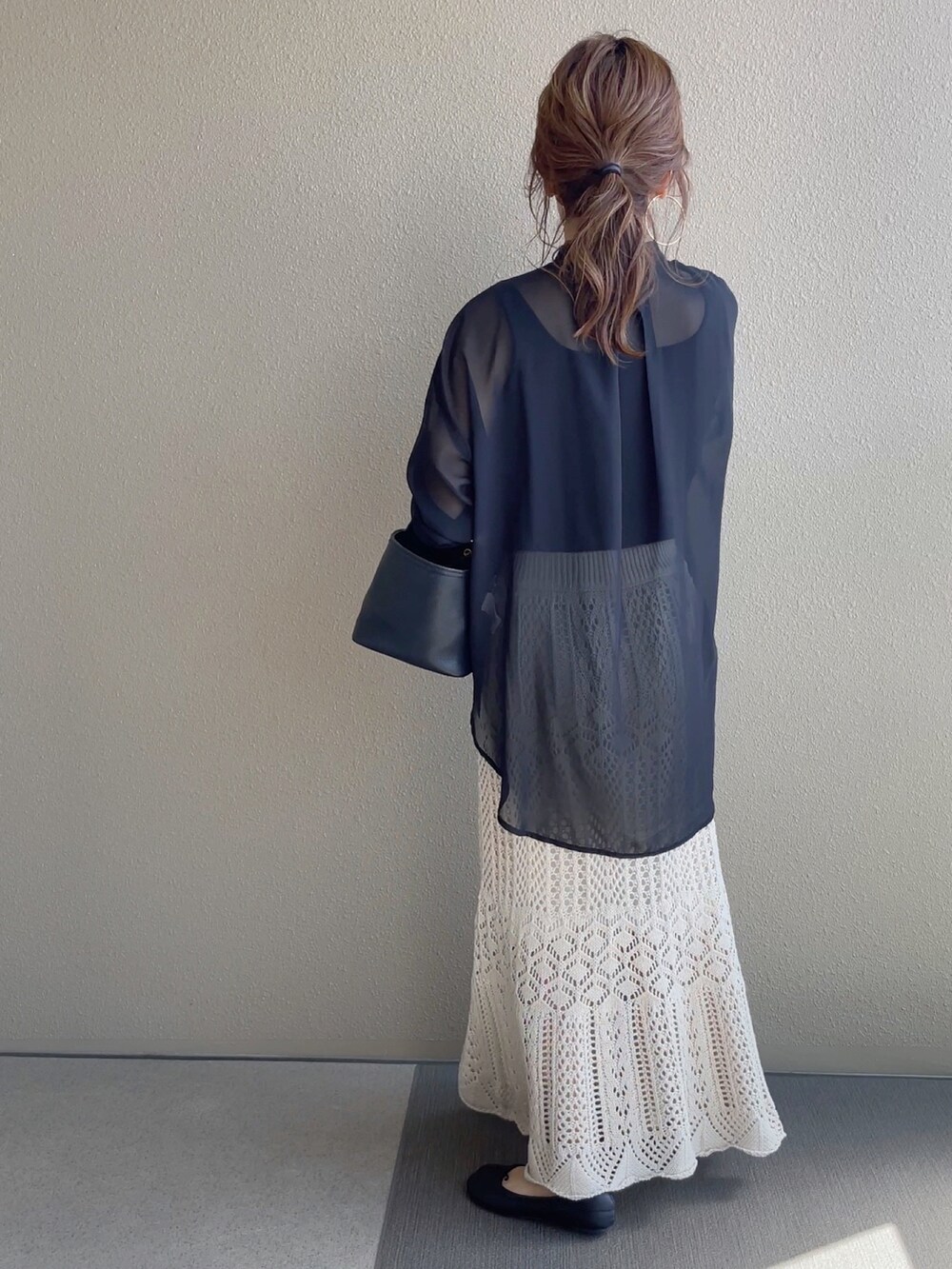 ホワイト系のスカート、ブラック系のTシャツ/カットソー、ブラウン系のベストを着用したレディースの春コーディネートの5枚目の写真