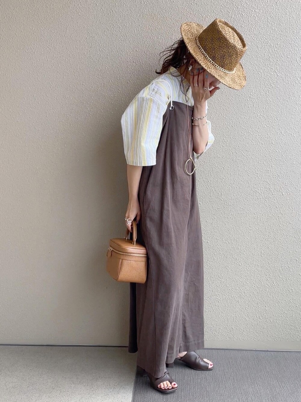 イエロー系のシャツ/ブラウス、ブラウン系のワンピース、ブラウン系のサンダルを着用したレディースの春コーディネートの5枚目の写真