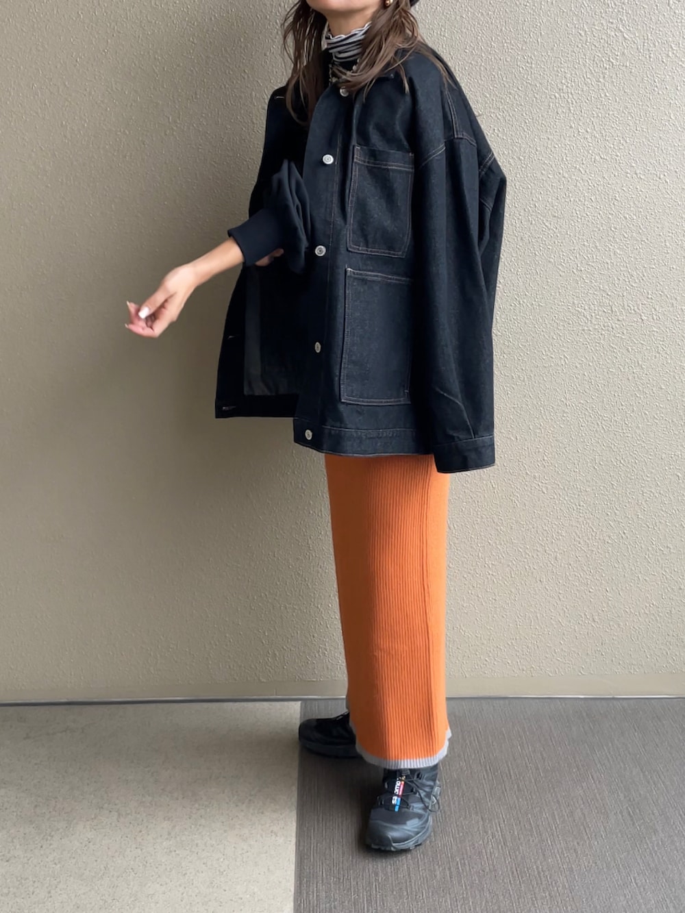 オレンジ系のスカート、ブラック系のスウェット、ブラック系のデニムジャケットを着用したレディースの秋コーディネートの3枚目の写真