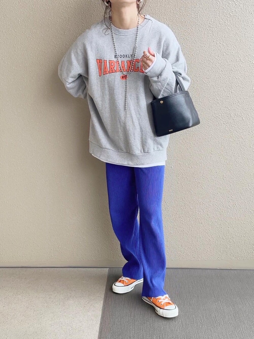 ブルー系のその他パンツ、グレー系のスウェット、オレンジ系のスニーカーを着用したレディースの冬コーディネートの3枚目の写真