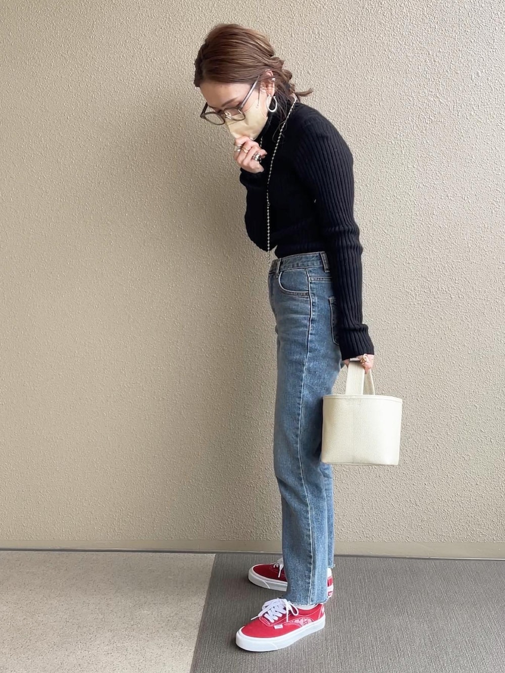 ホワイト系のデニムジャケット、ブルー系のデニムパンツ、レッド系のスニーカーを着用したレディースの冬コーディネートの3枚目の写真