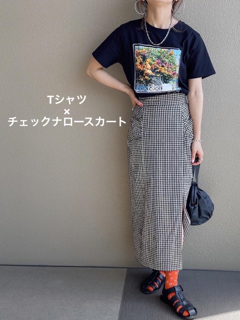 ブラック系のTシャツ/カットソー、ブラック系のスカート、グリーン系のベストを着用したレディースの春コーディネートの2枚目の写真