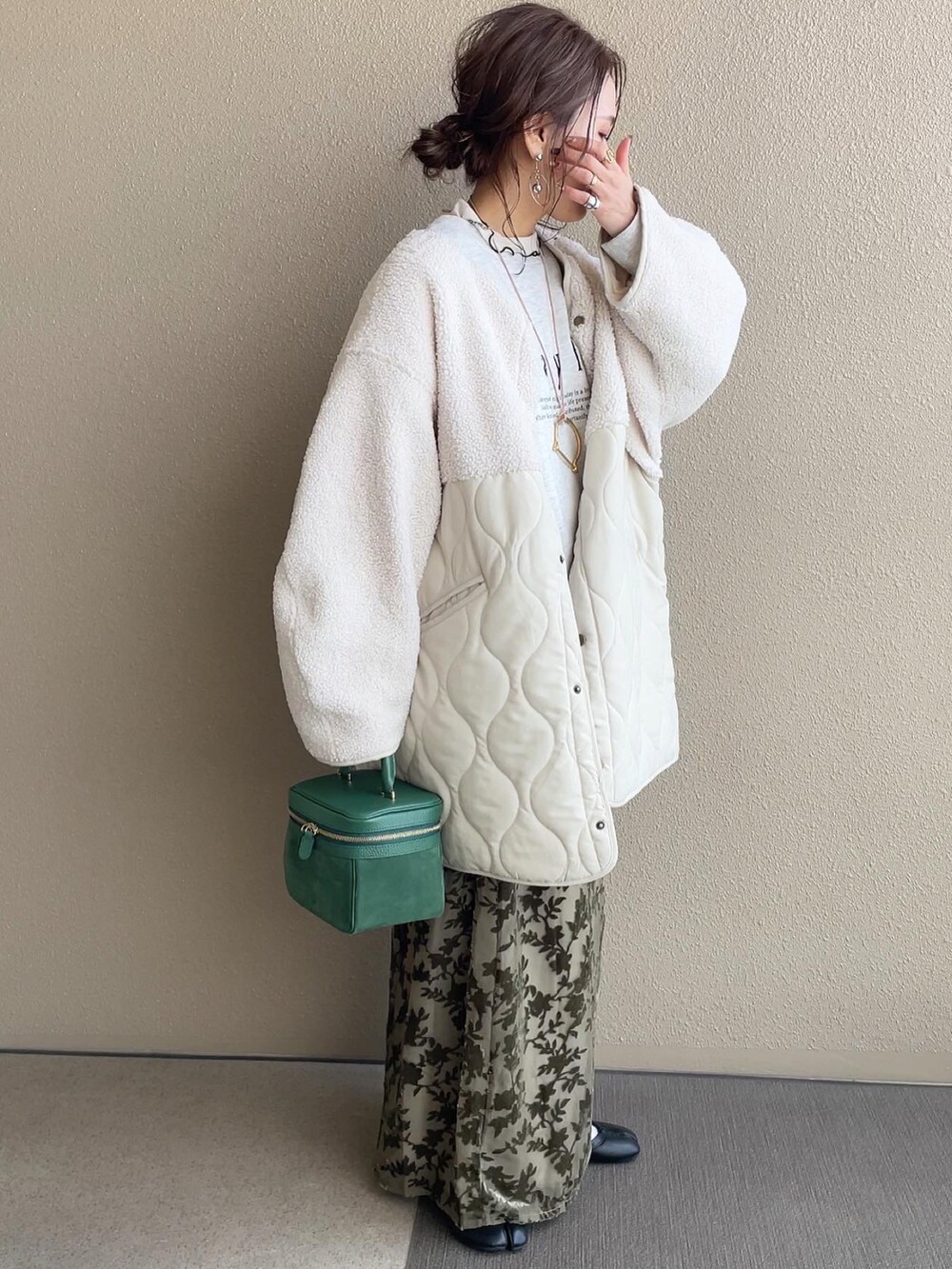 グリーン系のスカート、グレー系のスウェット、ブラック系のパンプスを着用したレディースの冬コーディネートの4枚目の写真