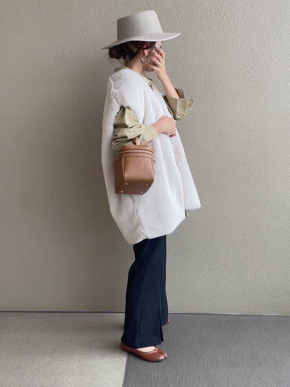 ホワイト系のベスト、ベージュ系のシャツ/ブラウス、ブラック系のスラックスを着用したレディースの秋コーディネートの2枚目の写真