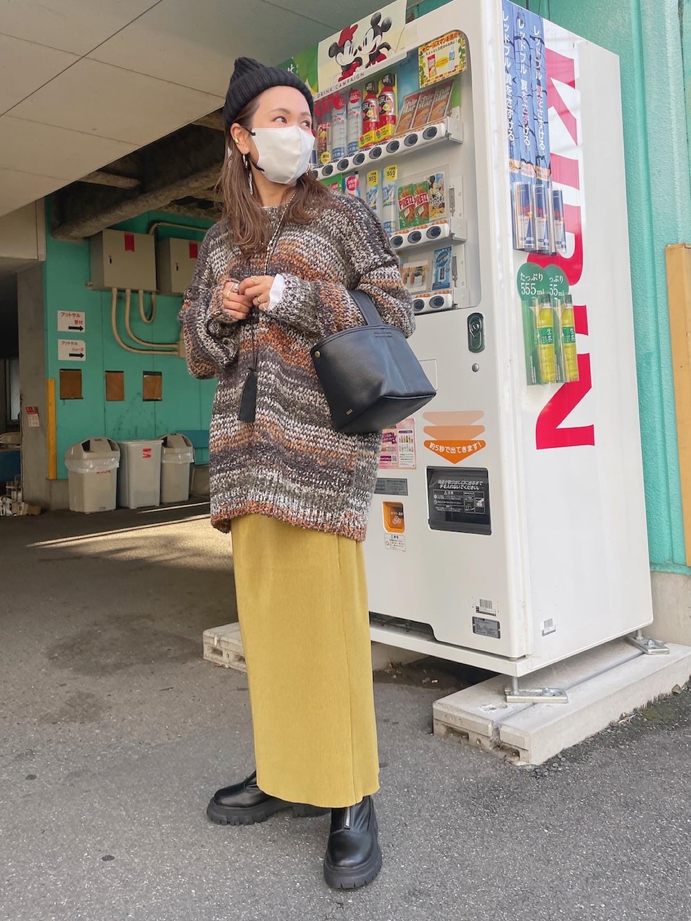 グリーン系のカーディガン/ボレロ、イエロー系のスカートを着用したレディースの秋コーディネートの4枚目の写真