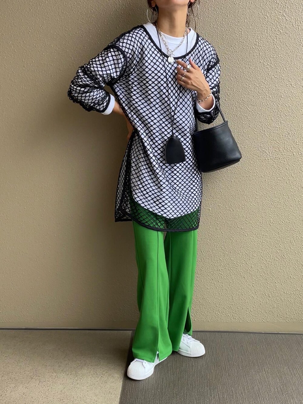 ベージュ系のスウェット、グリーン系のベスト、グリーン系のスラックスを着用したレディースの秋コーディネートの3枚目の写真