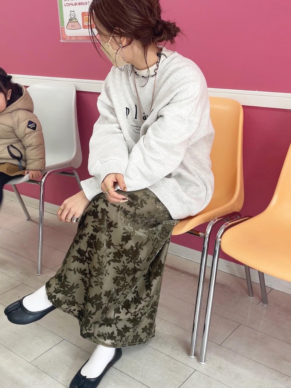 グリーン系のスカート、グレー系のスウェット、ブラック系のパンプスを着用したレディースの冬コーディネートの5枚目の写真