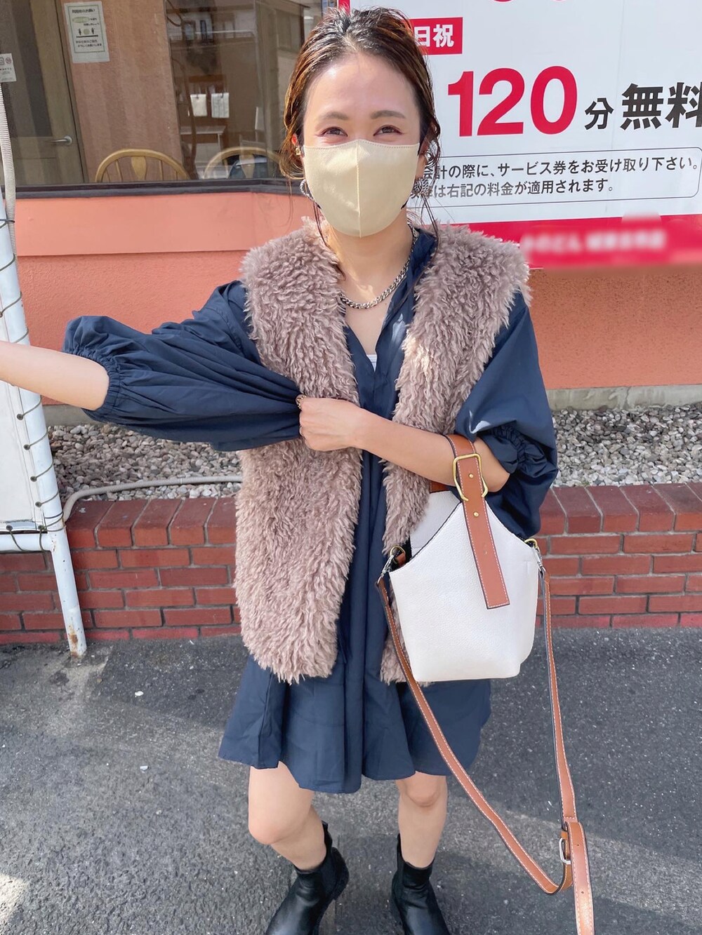 ベージュ系のベスト、ブルー系のワンピース/ドレス、ブラック系のブーツを着用したレディースの秋コーディネートの5枚目の写真