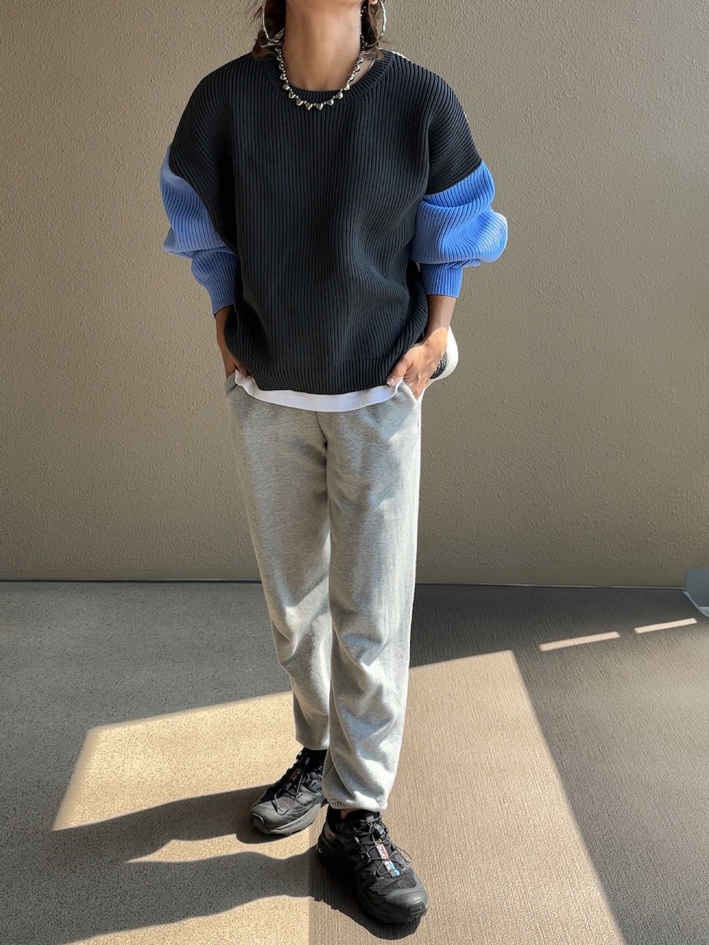 グレー系のニット/セーター、グレー系のスウェットパンツ、ブラック系のニットキャップ/ビーニーを着用したレディースの秋コーディネートの2枚目の写真