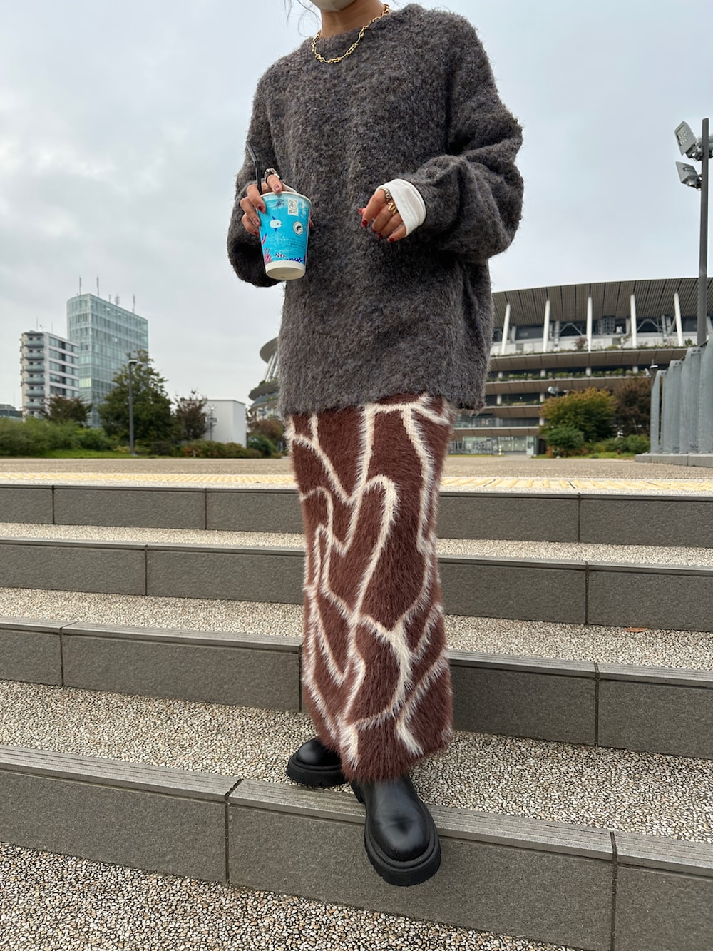 グレー系のニット/セーター、ブラウン系のスカートを着用したレディースの冬コーディネートの3枚目の写真