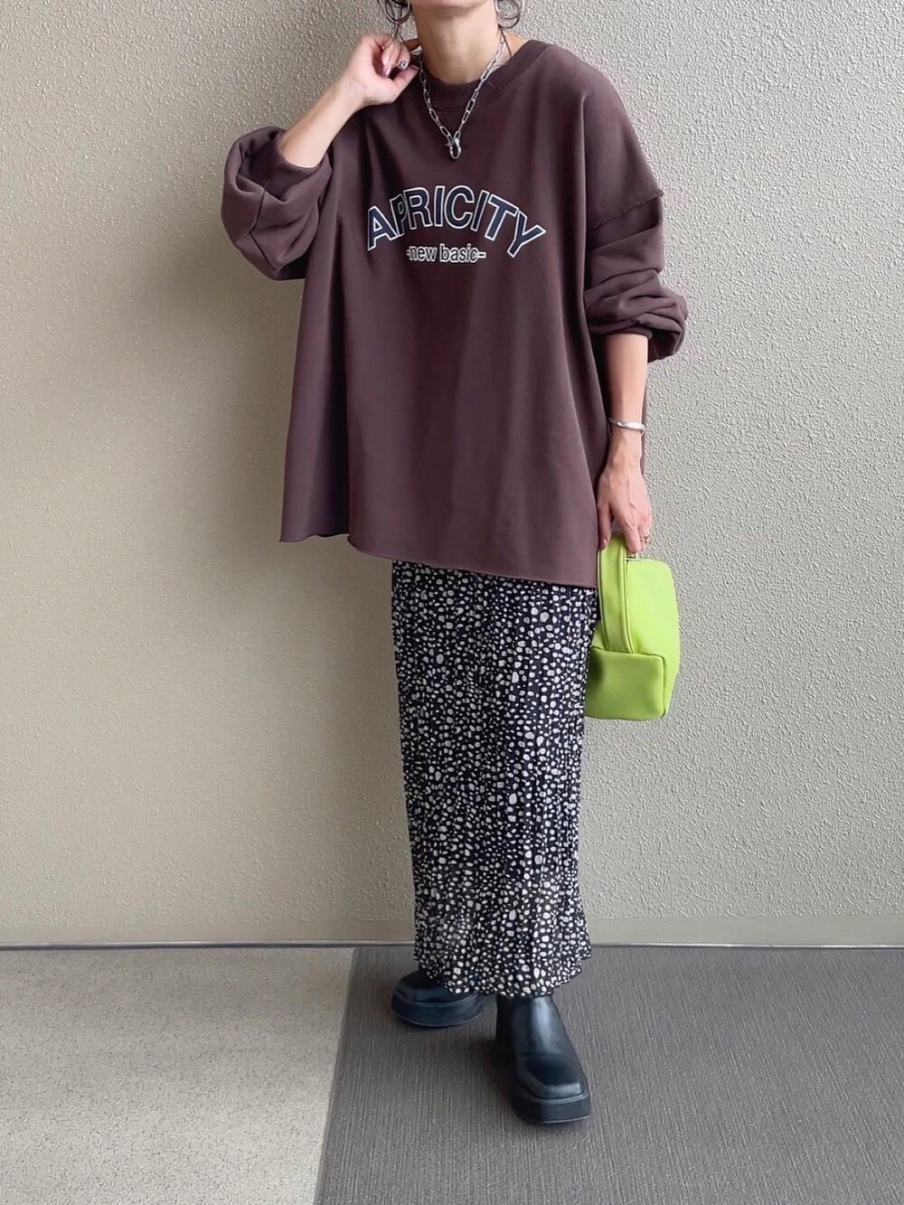 ピンク系のスウェット、ホワイト系のベスト、ブルー系のショルダーバッグを着用したレディースの秋コーディネートの2枚目の写真