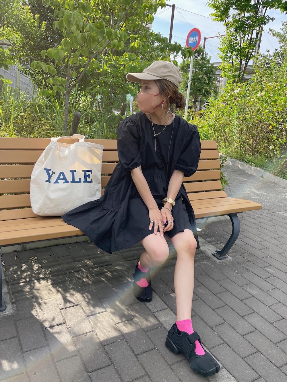 ブラック系のワンピース、ホワイト系のトートバッグ、ブラック系のサンダルを着用したレディースの夏コーディネートの3枚目の写真