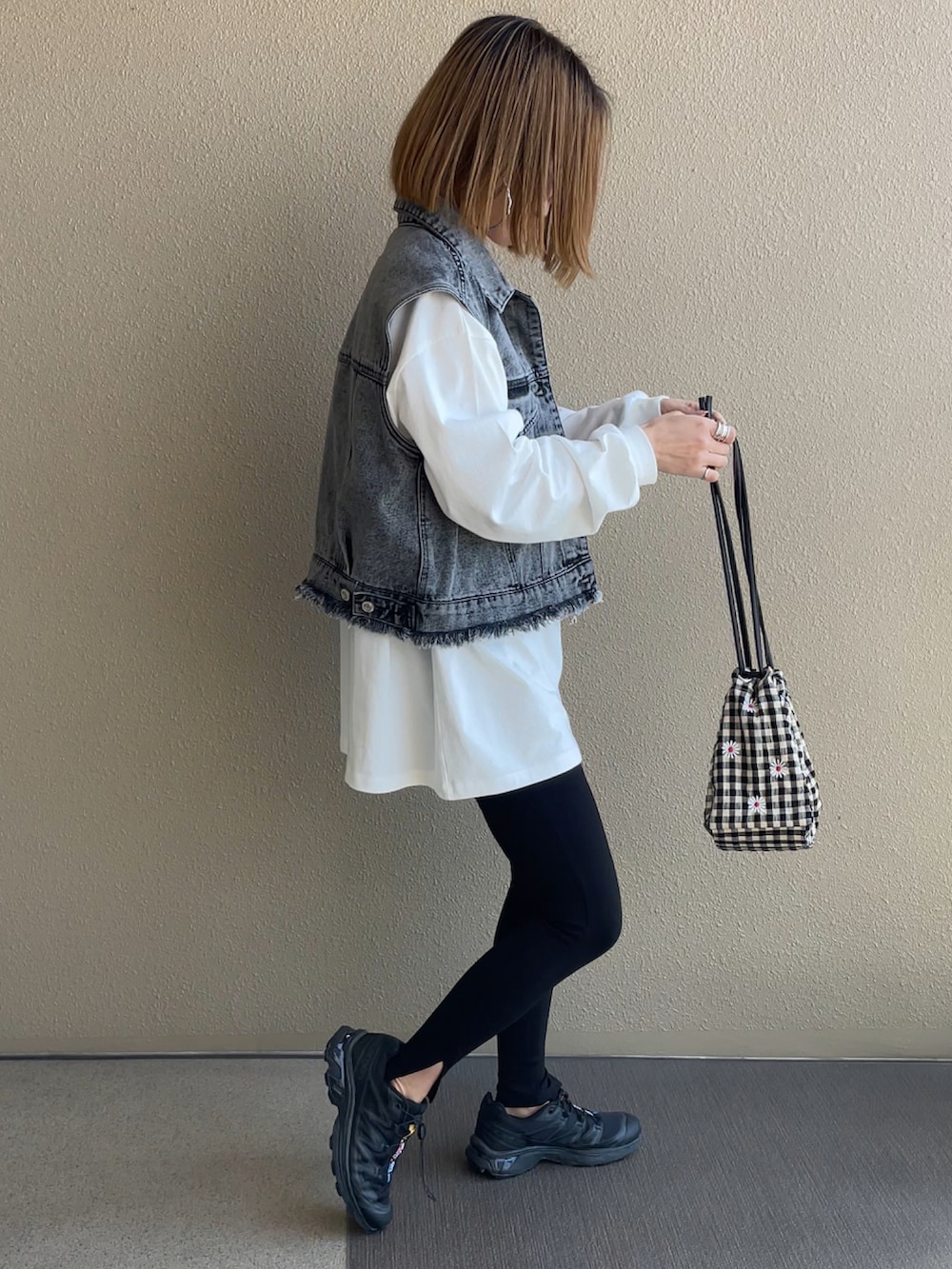 ホワイト系のTシャツ/カットソー、ブラック系のスニーカー、その他のハンドバッグを着用したレディースの春コーディネートの4枚目の写真