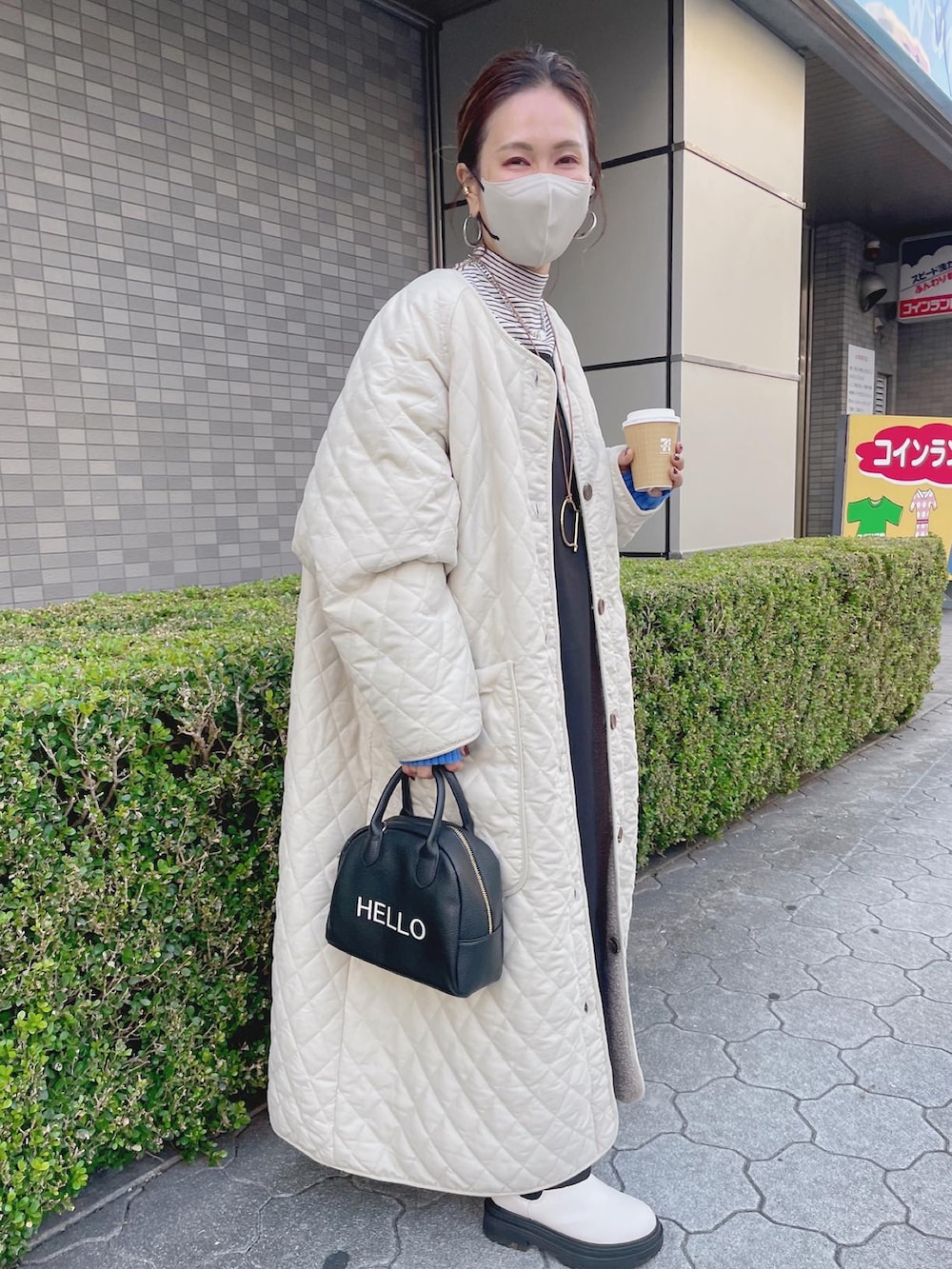 ホワイト系のその他アウター、ブラック系のワンピース、ブラック系のハンドバッグを着用したレディースの秋コーディネートの5枚目の写真