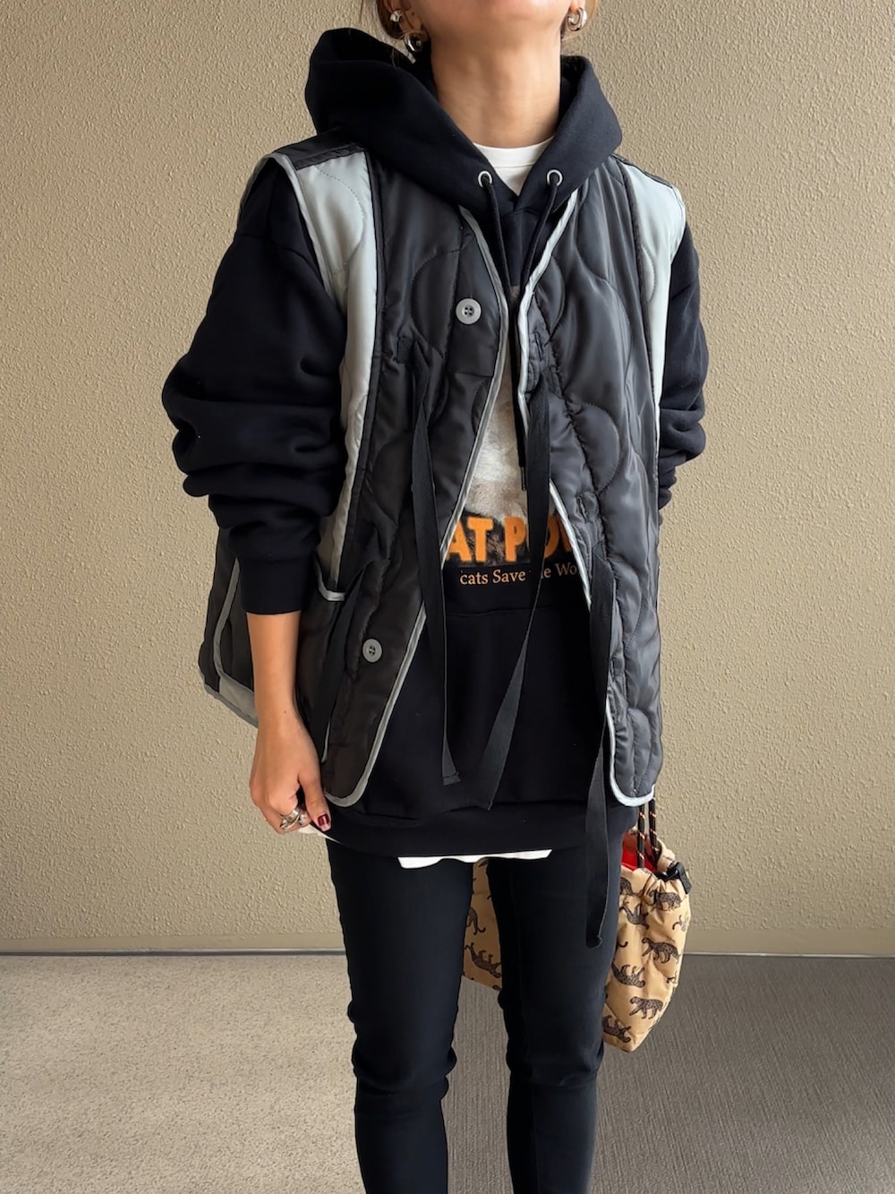 ブラック系のその他アウター、ブラック系のパーカー、ベージュ系のショルダーバッグを着用したレディースの秋コーディネートの4枚目の写真