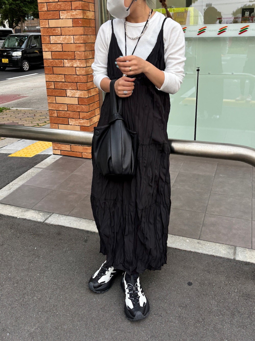 ホワイト系のTシャツ/カットソー、ブラック系のワンピース/ドレス、ホワイト系のサンダルを着用したレディースの春コーディネートの4枚目の写真