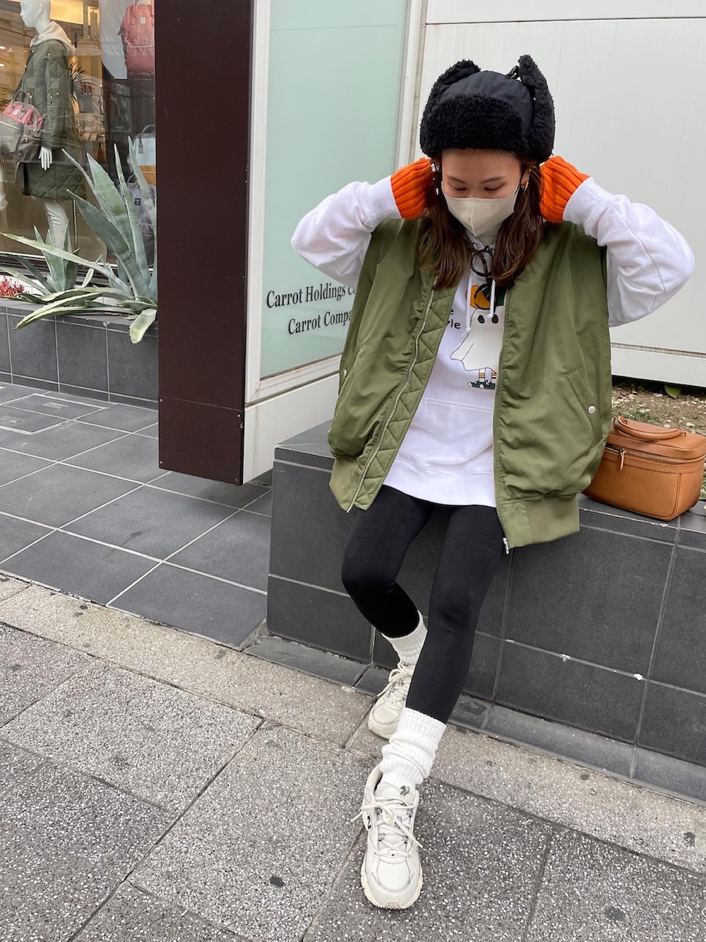 グリーン系のMA-1、ホワイト系のスニーカー、ブラック系のハットを着用したレディースの冬コーディネートの2枚目の写真
