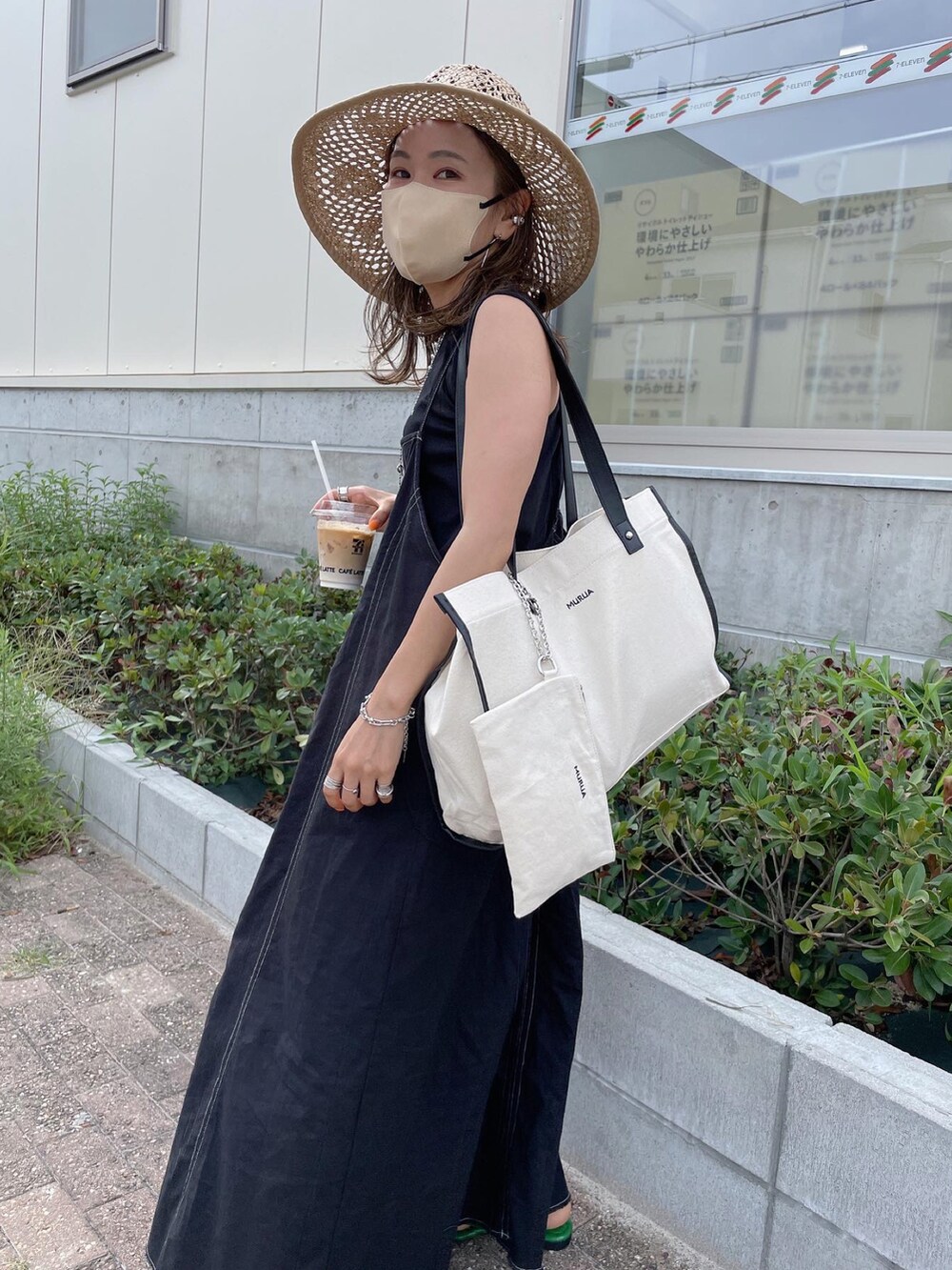 ブラック系のワンピース、ホワイト系のトートバッグ、グリーン系のサンダルを着用したレディースの夏コーディネートの4枚目の写真