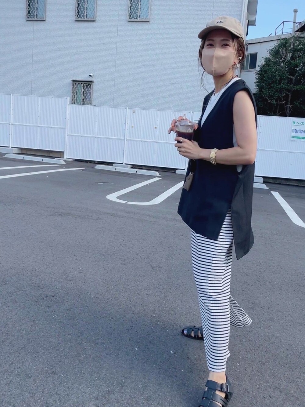 ブラック系のベスト、ブラック系のサンダル、その他のスカートを着用したレディースの夏コーディネートの3枚目の写真