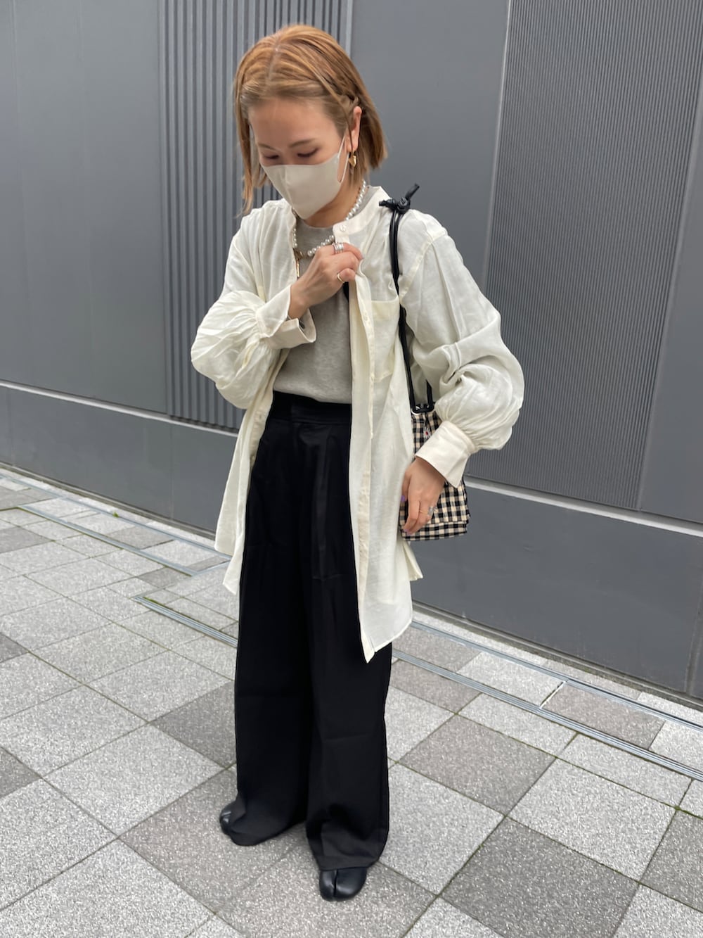 グレー系のニット/セーター、ブラック系のスラックス、その他のハンドバッグを着用したレディースの春コーディネートの3枚目の写真