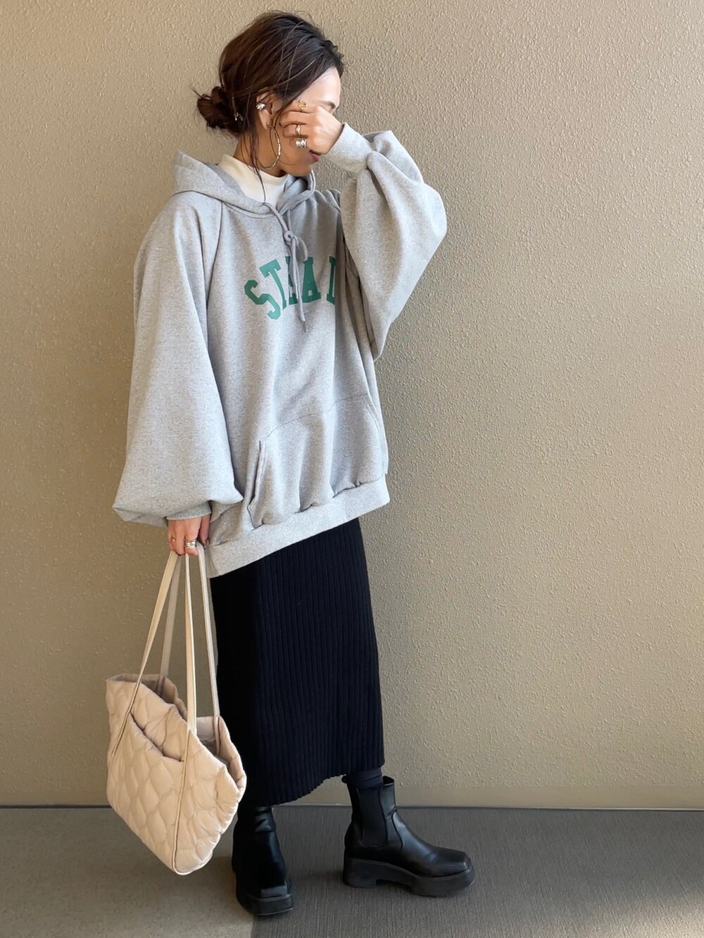 グリーン系のノーカラージャケット、グレー系のパーカー、ベージュ系のトートバッグを着用したレディースの冬コーディネートの3枚目の写真