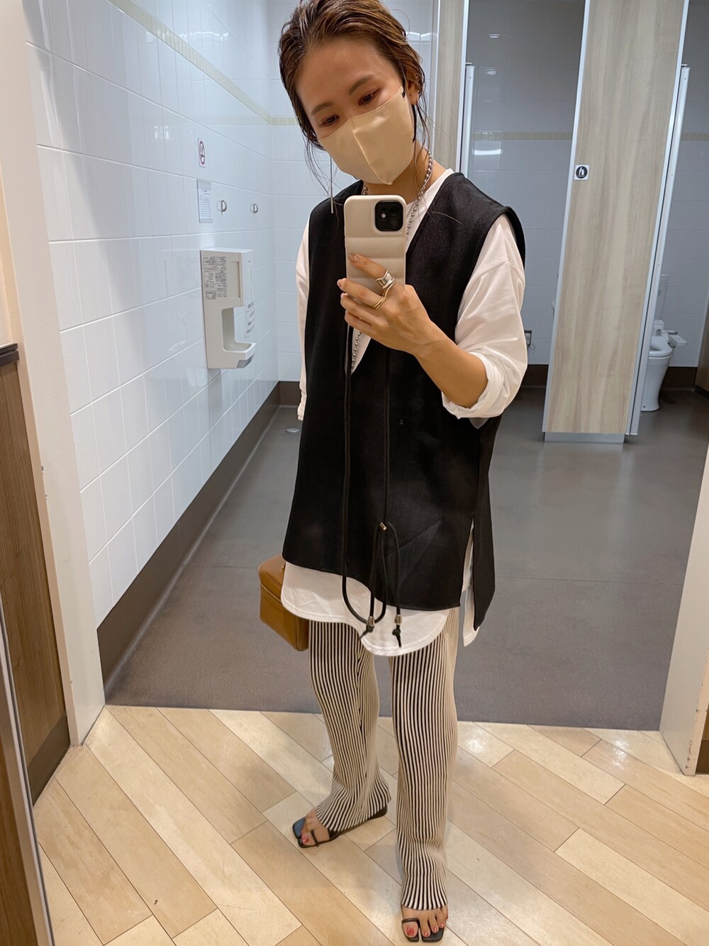 ホワイト系のTシャツ/カットソー、ブラック系のベストを着用したレディースの秋コーディネートの4枚目の写真