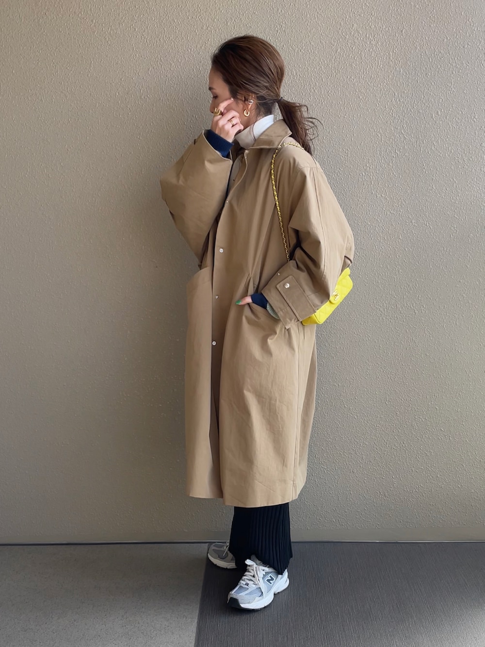 グリーン系のカーディガン/ボレロ、ブラック系のスカート、ベージュ系のステンカラーコートを着用したレディースの冬コーディネートの4枚目の写真