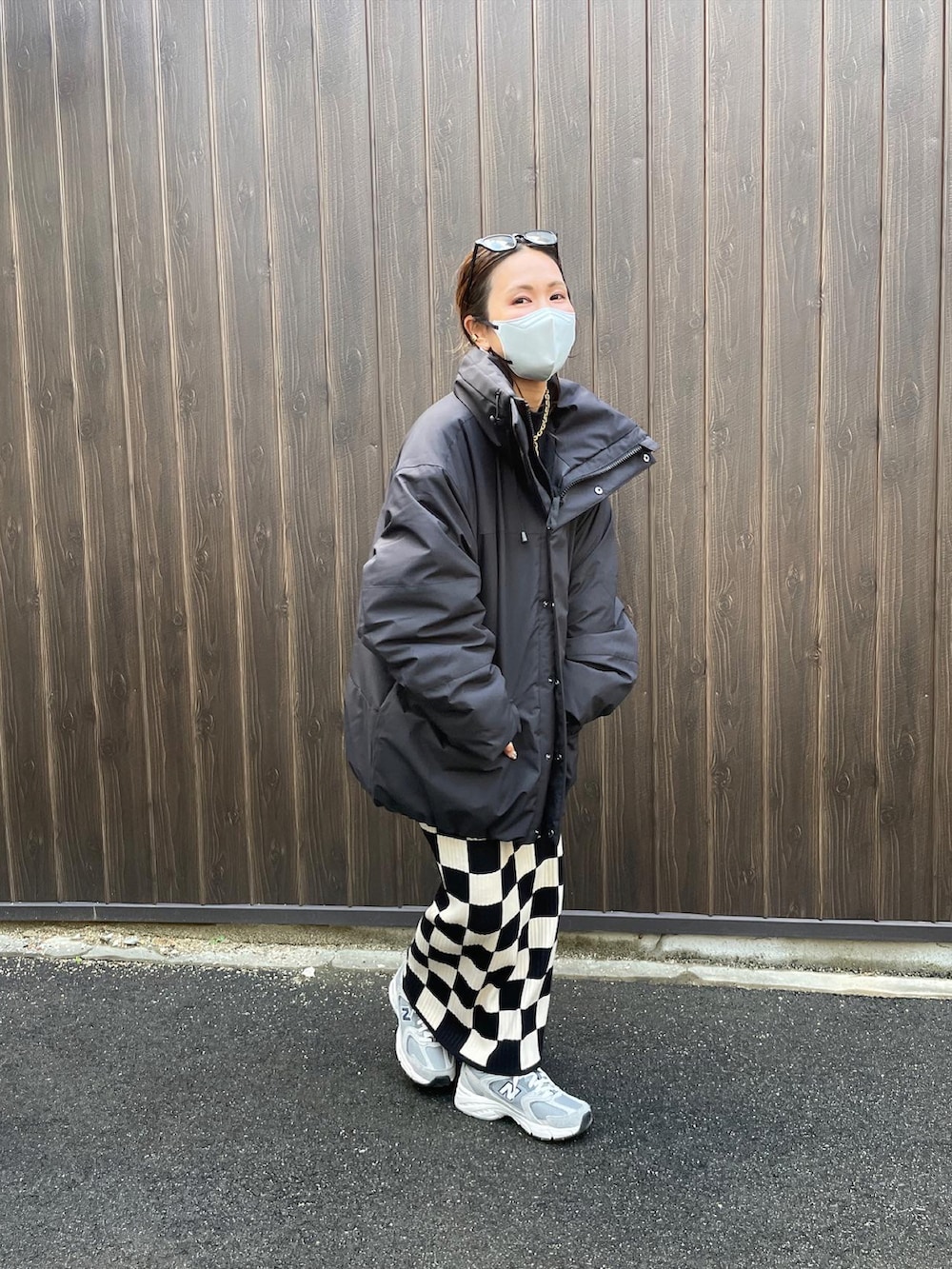 ブラック系のダウンジャケット/コート、ホワイト系のスカートを着用したレディースの冬コーディネートの4枚目の写真