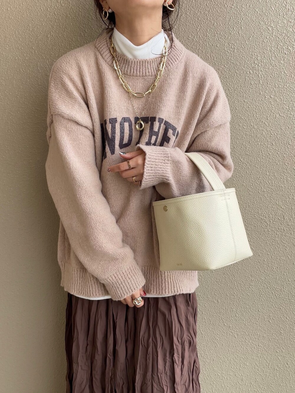 ベージュ系のニット/セーター、ブラウン系のスカート、ブラウン系のパンプスを着用したレディースの冬コーディネートの3枚目の写真