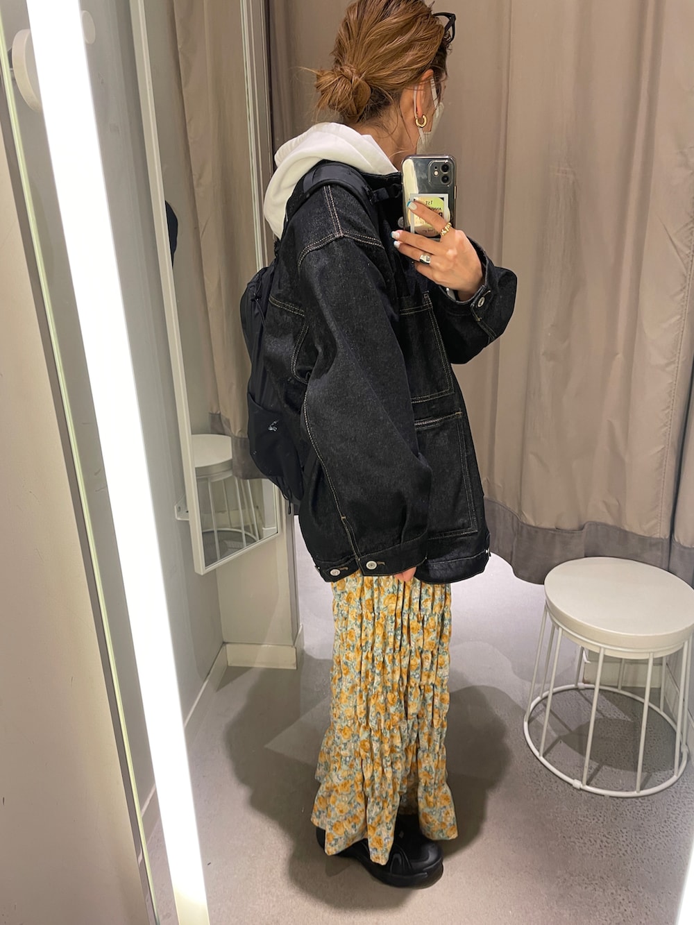 ホワイト系のパーカー、ブラック系のデニムジャケット、イエロー系のスカートを着用したレディースの冬コーディネートの2枚目の写真