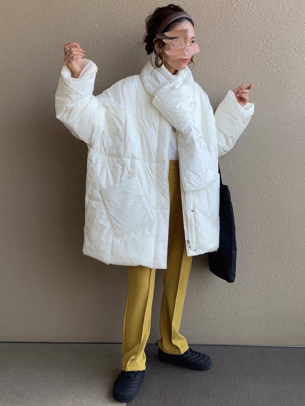 ホワイト系のダウンジャケット/コート、イエロー系のその他パンツ、ブラック系のトートバッグを着用したレディースの秋コーディネートの2枚目の写真